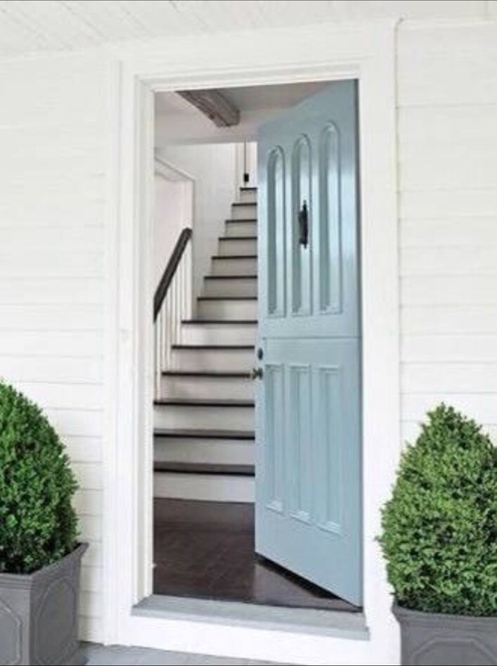 Freshly painted pale blue front door and white exterior trim